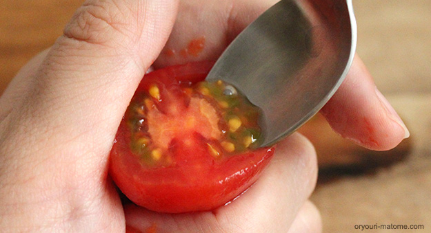 トマトを半分に切り、スプーンで種を取り除く